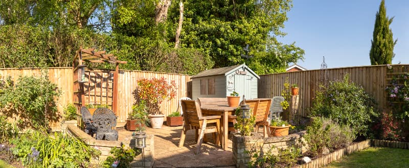 Pretty garden with furniture, shed and plants
