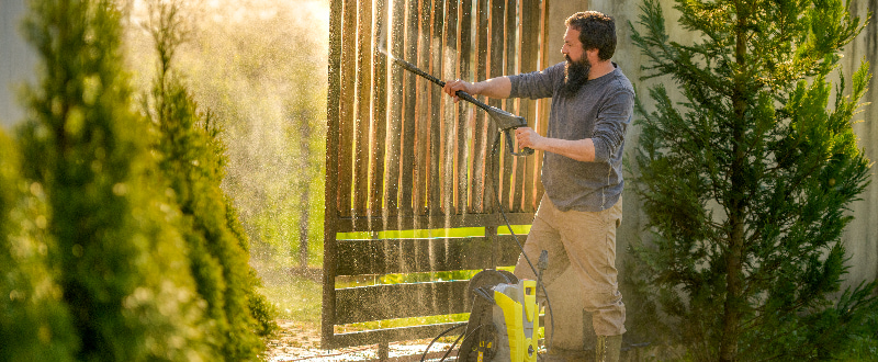 man power washing his fence